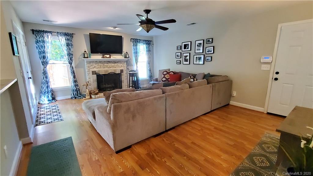 20700 Willow Pond Road Cornelius, NC 28031 - Photo 24 of 47 a living room with furniture a flat screen tv and a fireplace