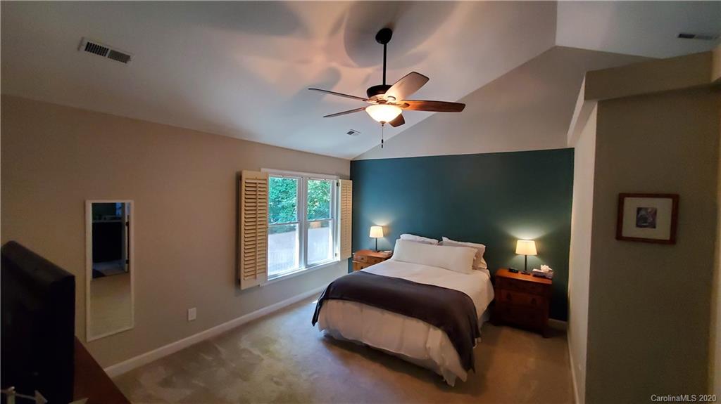 20700 Willow Pond Road Cornelius, NC 28031 - Photo 28 of 47 a bedroom with a bed and a chandelier