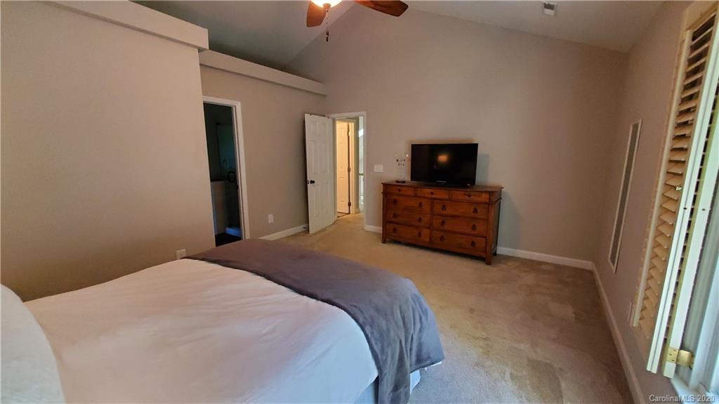 20700 Willow Pond Road Cornelius, NC 28031 - Photo 30 of 47 a bedroom with a bed and a flat tv screen on dresser