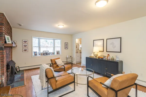 a living room with furniture a desk and chair with wooden floor