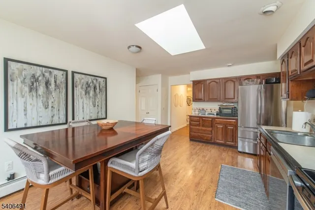 a kitchen with stainless steel appliances granite countertop a kitchen island a table and chairs
