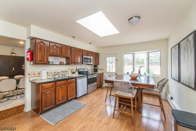 a dining hall with stainless steel appliances granite countertop a stove and a dining table view
