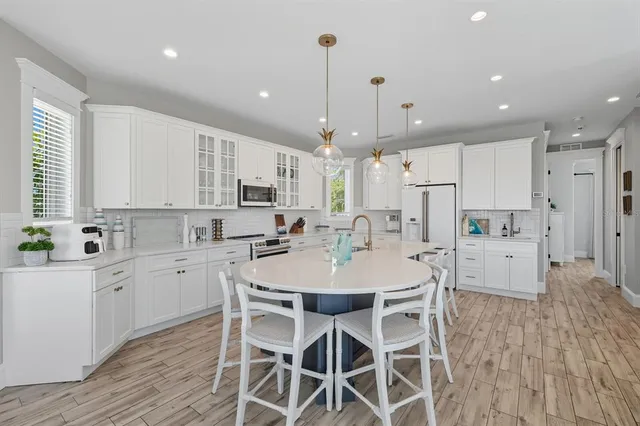 a dining room with furniture a chandelier and wooden floor