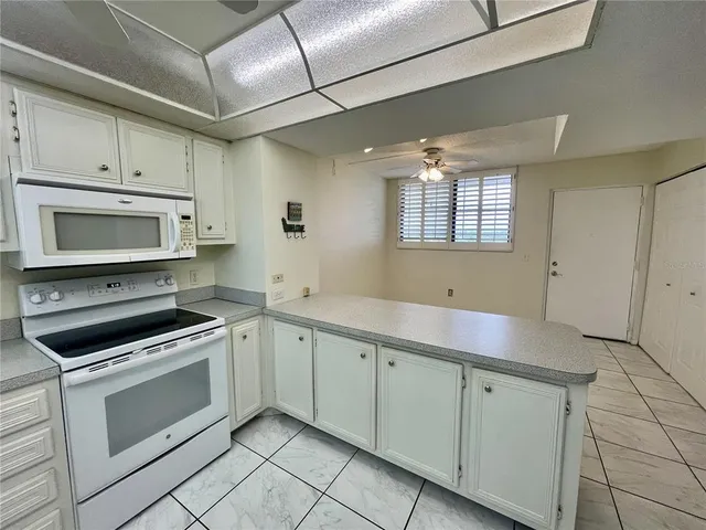 a kitchen with white cabinets appliances and a sink