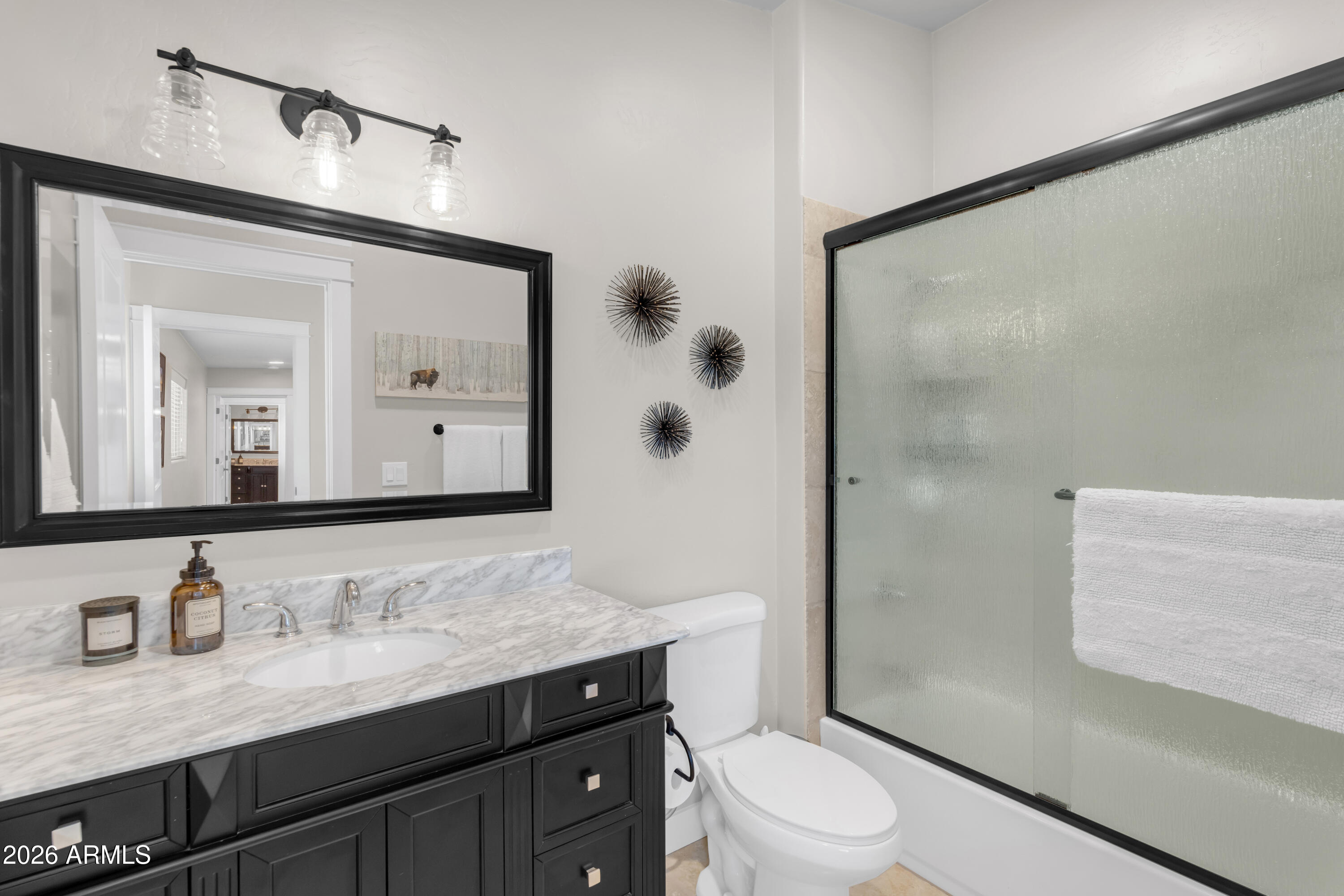 17975 Hopi Road Munds Park, AZ 86017 - Photo 29 of 58 a bathroom with a granite countertop sink toilet a mirror a vanity and shower