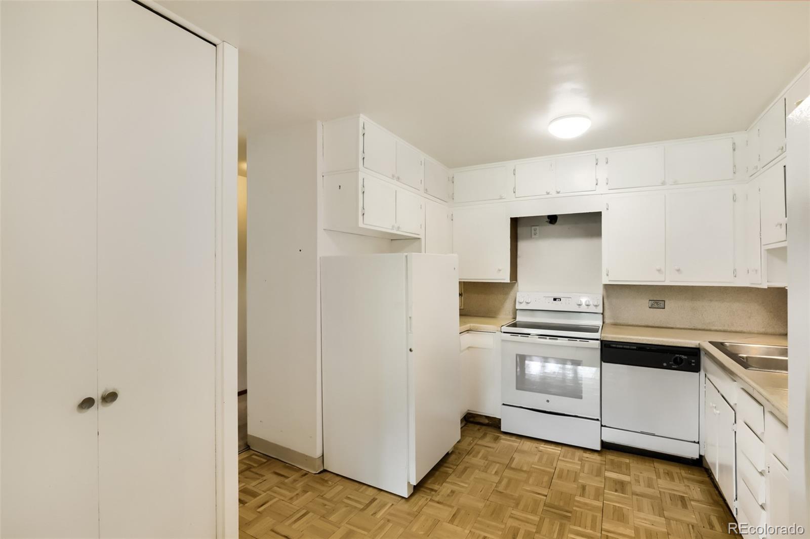 625 South Clinton Street, Unit 7B Denver, CO 80247 - Photo 2 of 22 a kitchen with white cabinets and white appliances