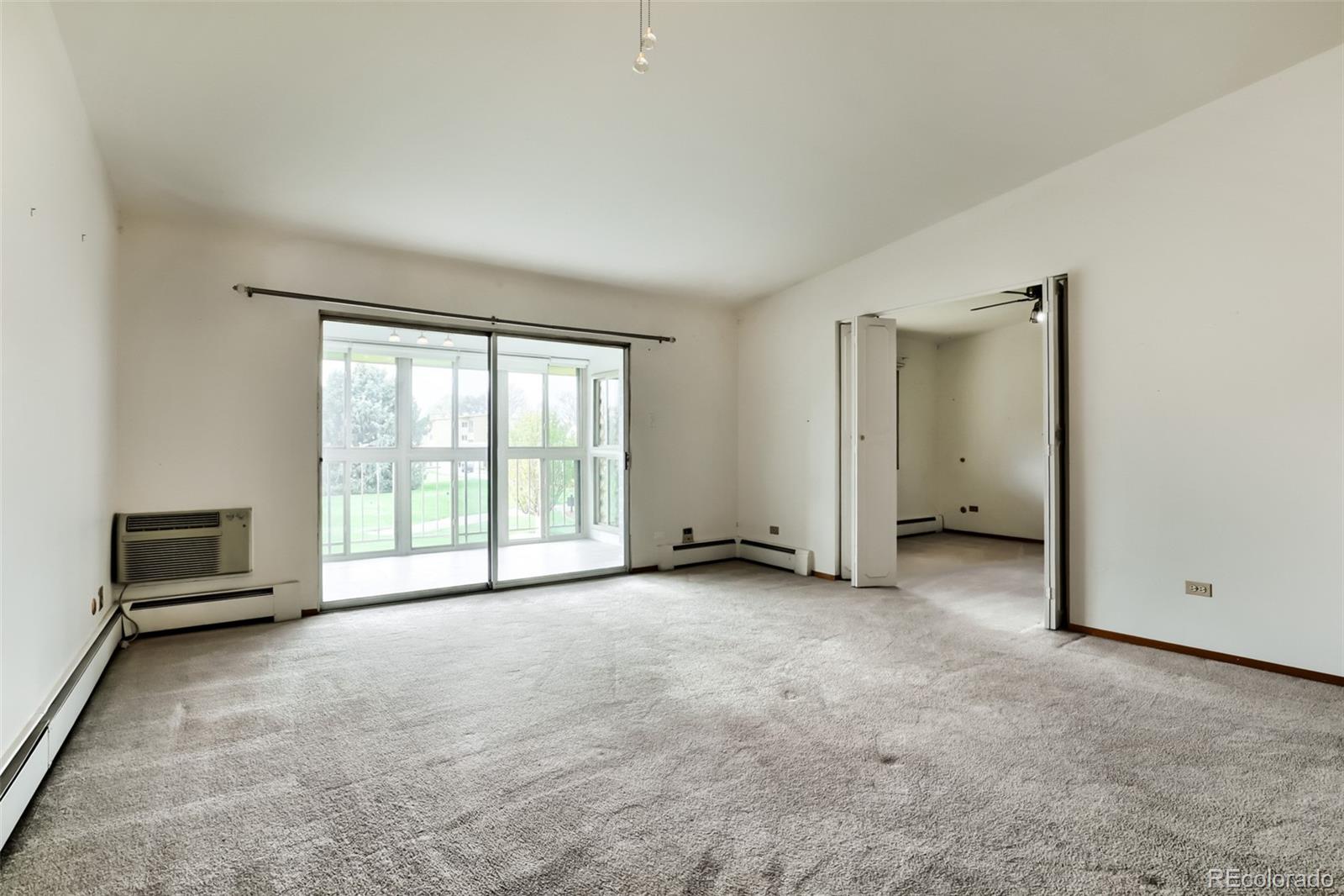 625 South Clinton Street, Unit 7B Denver, CO 80247 - Photo 4 of 22 an empty room with furniture and a window