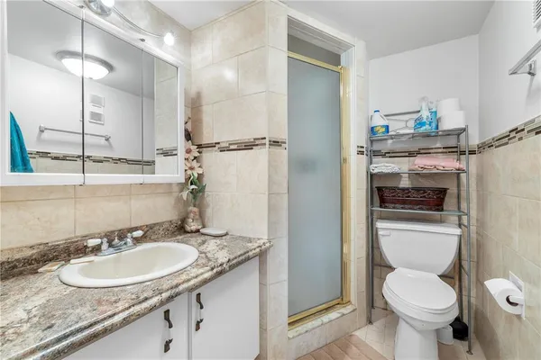 a bathroom with a granite countertop toilet sink and mirror