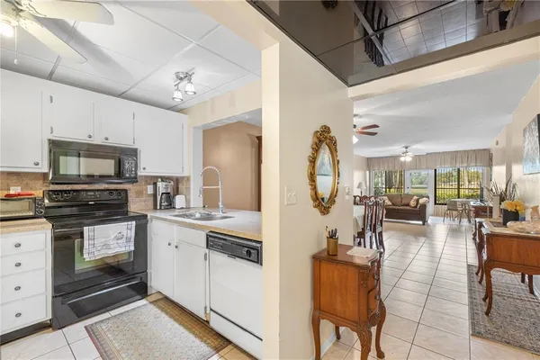 a view of kitchen with sink microwave refrigerator and furniture