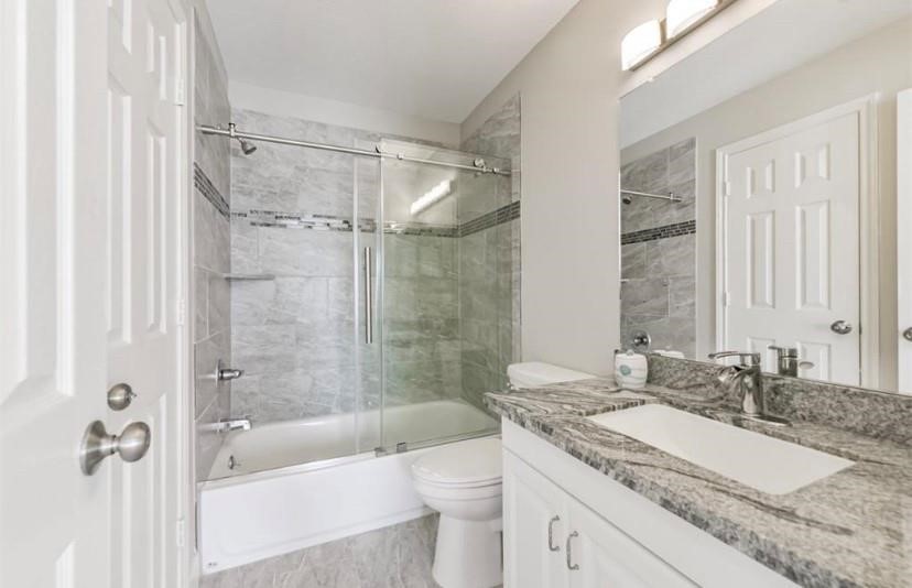 8002 Harbor Point Drive Houston, TX 77071 - Photo 17 of 25 a bathroom with a granite countertop sink a toilet and shower
