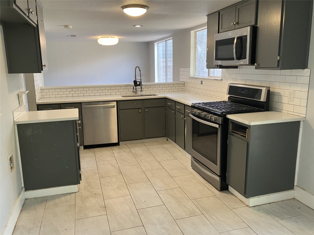7700 Copperas Drive Austin, TX 78749 - Photo 11 of 14 a kitchen with stainless steel appliances granite countertop a stove a sink and a microwave