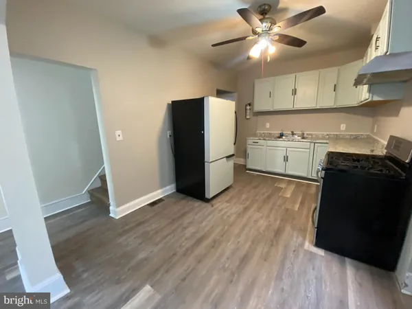 a kitchen with a refrigerator and a stove top oven