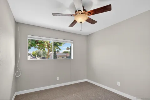 en empty room with window and ceiling fan