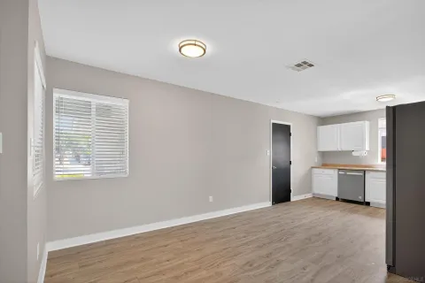 a view of a kitchen with a sink dishwasher and wooden floor