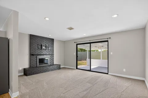 an empty room with fireplace and large window