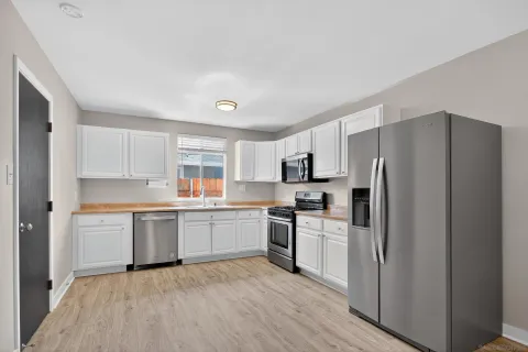 a kitchen with white cabinets and stainless steel appliances