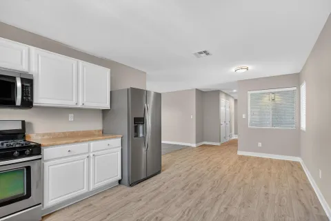 a view of a kitchen with electric appliances and cabinets