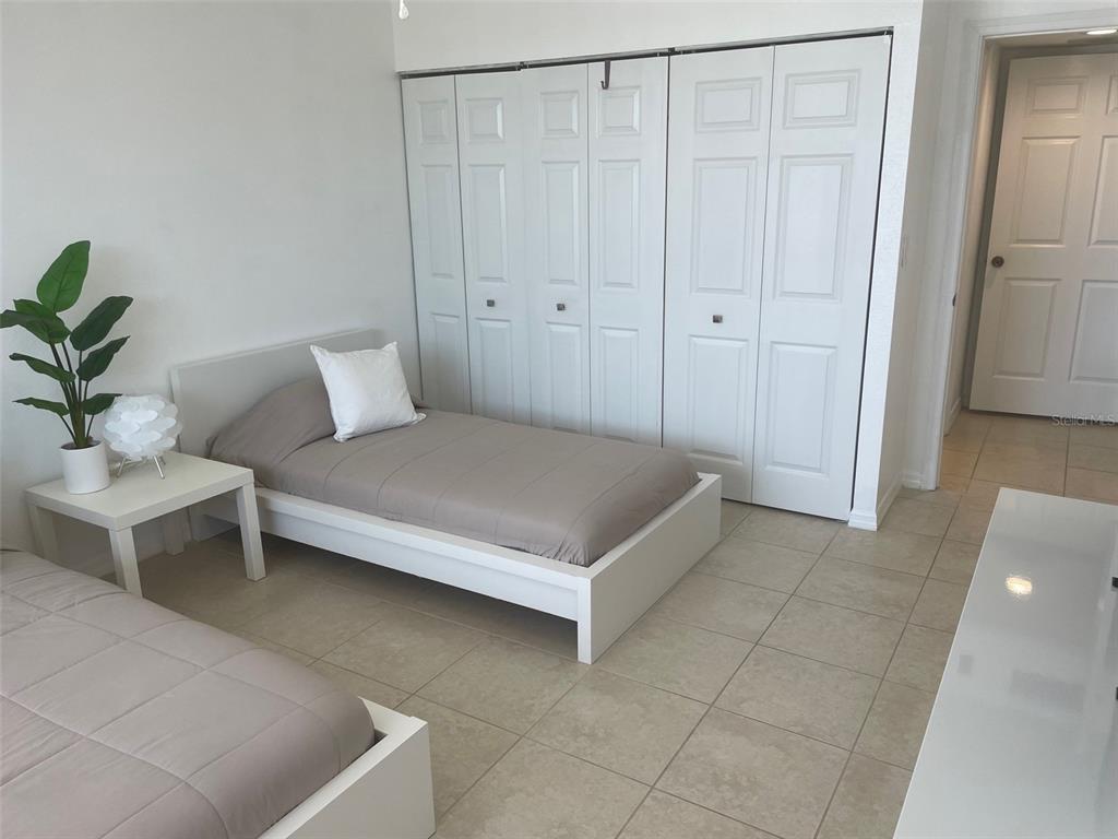 1 Key Capri, Unit 104W Treasure Island, FL 33706 - Photo 26 of 49 a bedroom with a bed and a potted plant