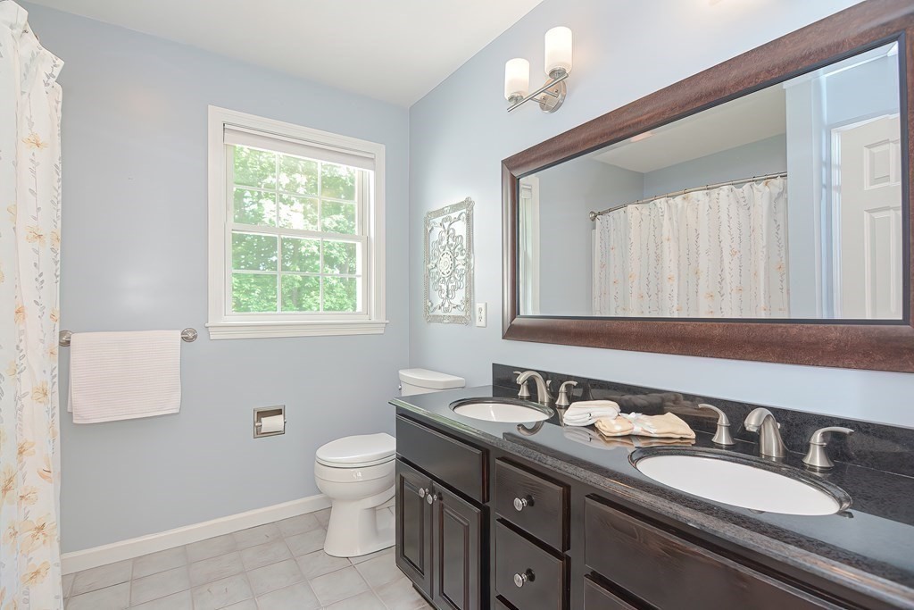 38 Pennock Road Ashland, MA 01721 - Photo 25 of 40 a bathroom with a granite countertop double vanity sink a mirror and a toilet