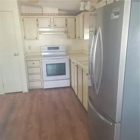 a kitchen with a white stove refrigerator and cabinets