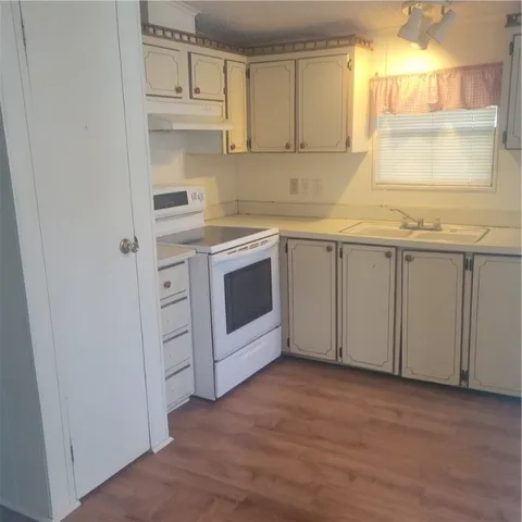 a kitchen with granite countertop white cabinets and white appliances