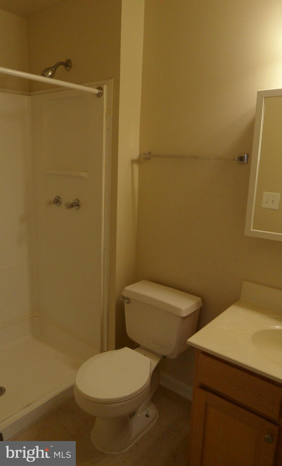18318 Streamside Drive, Unit 304 Gaithersburg, MD 20879 - Photo 13 of 30 a white toilet sitting next to a bathroom sink