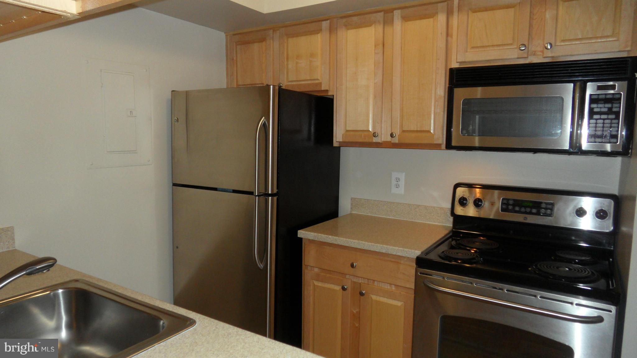 18318 Streamside Drive, Unit 304 Gaithersburg, MD 20879 - Photo 10 of 30 a kitchen with a refrigerator stove and microwave