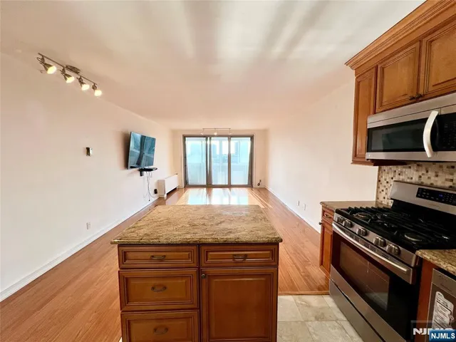a kitchen with kitchen island granite countertop a stove and a sink