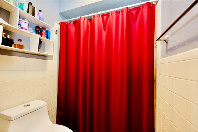 a white toilet and shower curtain