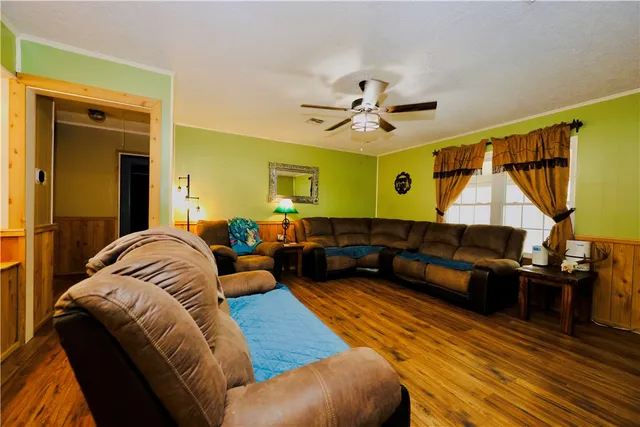 a living room with furniture ceiling fan and a wooden floor