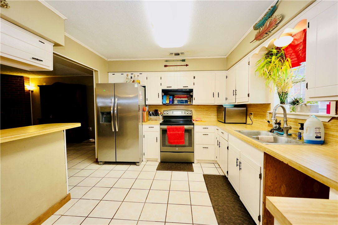 903 McGuill Road Goliad, TX 77963 - Photo 4 of 17 a kitchen with stainless steel appliances a stove refrigerator and cabinets