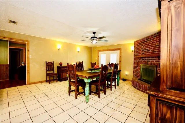 a living room with furniture a dining table and a fireplace