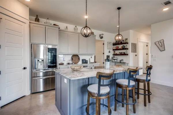 a kitchen with stainless steel appliances a table chairs and a chandelier