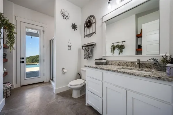 a bathroom with a granite countertop sink and a toilet