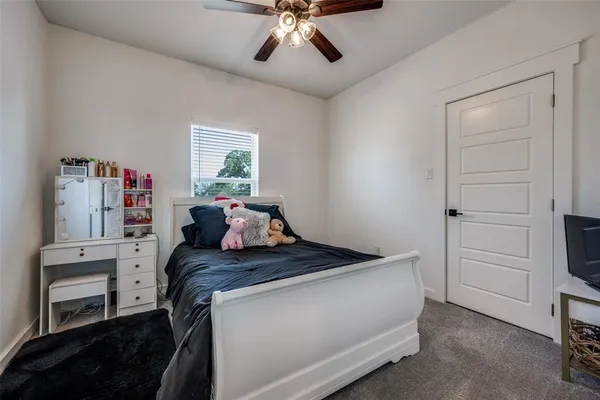 a bed room with a bed and a ceiling fan