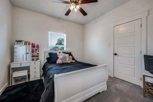 a bed room with a bed and a ceiling fan