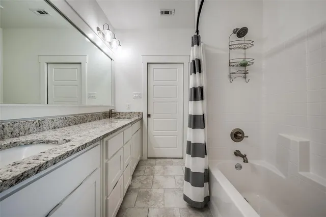 a bathroom with a granite countertop sink a toilet a mirror and shower