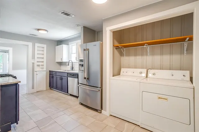a kitchen with a refrigerator sink and cabinets