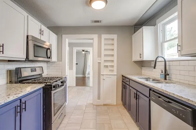 a kitchen with stainless steel appliances granite countertop a stove sink microwave and refrigerator