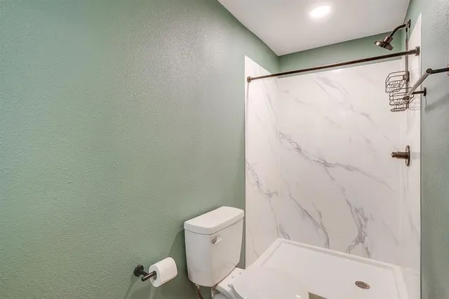 a white toilet sitting next to a bath tub and a shower