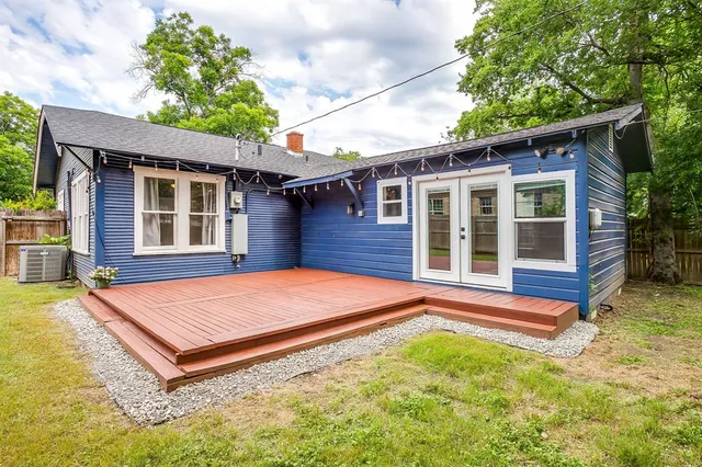 a backyard of a house with wooden deck and barbeque oven