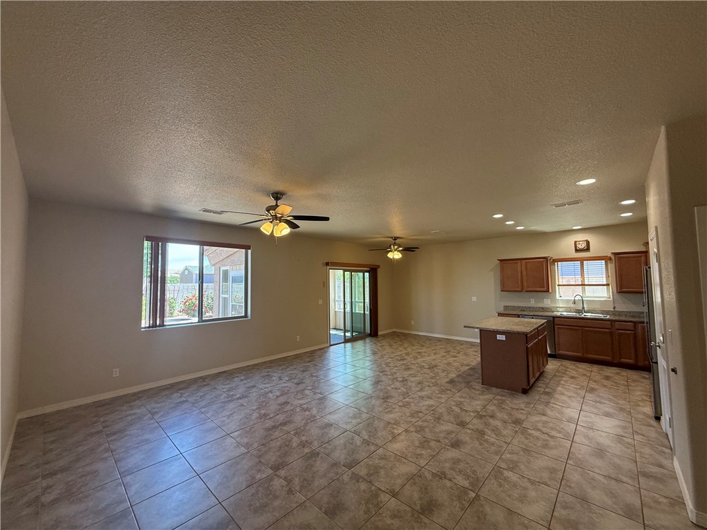 4786 East Old W Road Kingman, AZ 86401 - Photo 2 of 12 Open-concept interior featuring tile flooring throughout, a kitchen with wood cabinetry and a central island, and a screened patio access