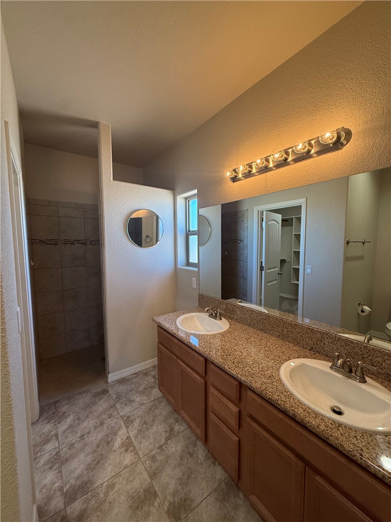 4786 East Old W Road Kingman, AZ 86401 - Photo 9 of 12 Bathroom featuring a dual vanity with granite-style countertops, wood cabinetry, and integrated sinks