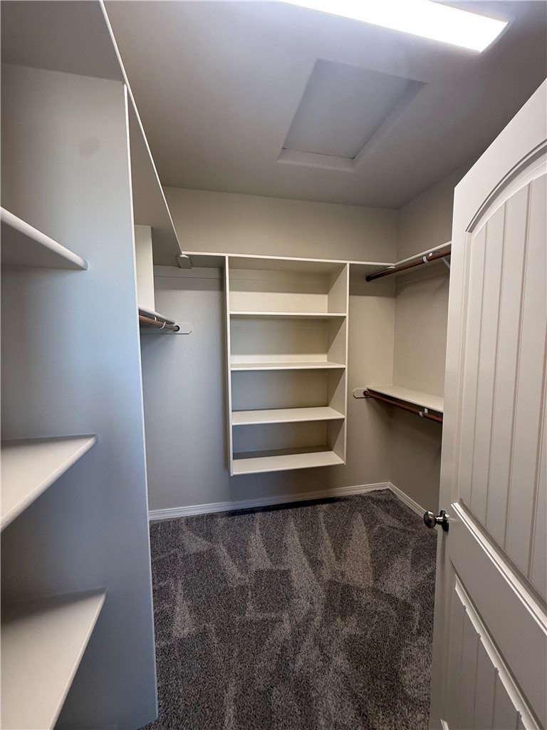 4786 East Old W Road Kingman, AZ 86401 - Photo 10 of 12 Walk-in closet featuring extensive built-in shelving, hanging rods, recessed ceiling lighting, and carpet flooring