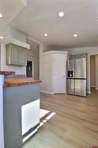 a view of kitchen with furniture and refrigerator