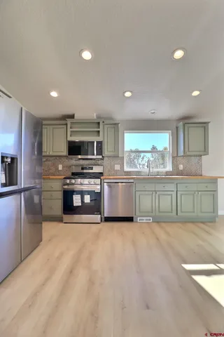 a large kitchen with stainless steel appliances granite countertop a stove a sink a refrigerator and a granite counter tops