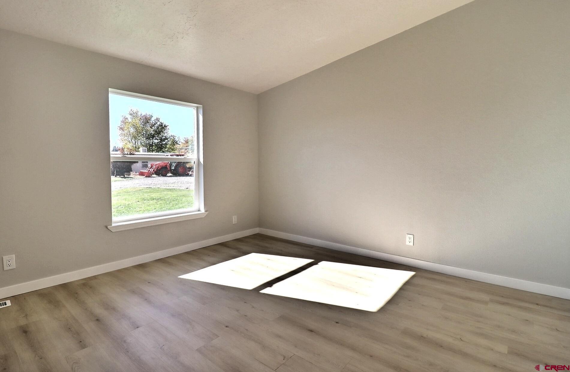 761 Stahl Road Paonia, CO 81428 - Photo 18 of 39 an empty room with wooden floor and windows