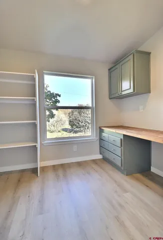 a view of a room with wooden floor and a window
