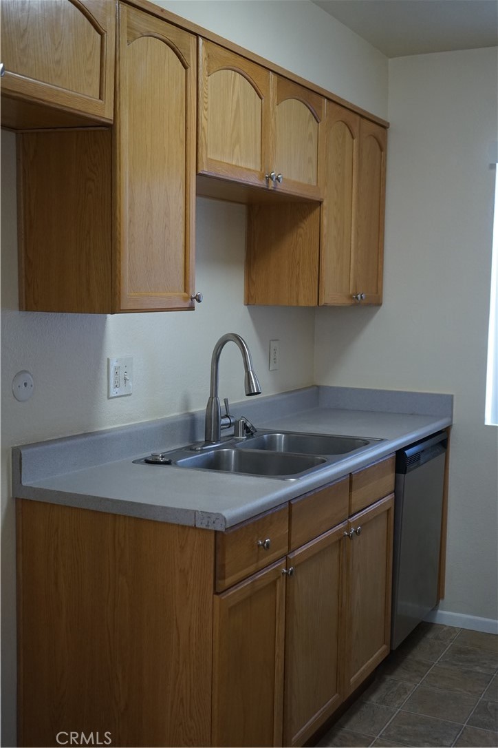 9090 Colony Place, Unit D Riverside, CA 92503 - Photo 4 of 24 a kitchen with stainless steel appliances granite countertop a sink dishwasher and cabinets with wooden floor