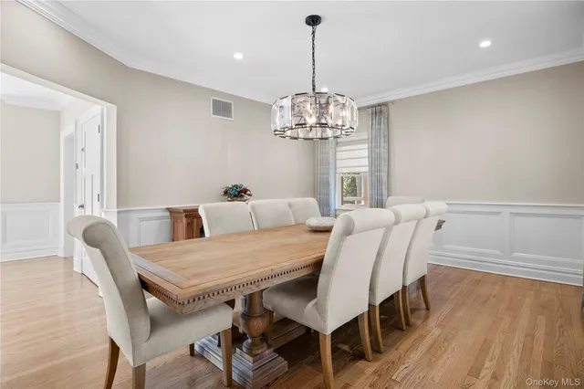 a view of a dining room with furniture wooden floor and chandelier